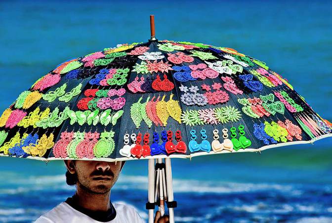 Strandverkäufer bringen im Hochsommer ihre knallbunte Ware unters Volk