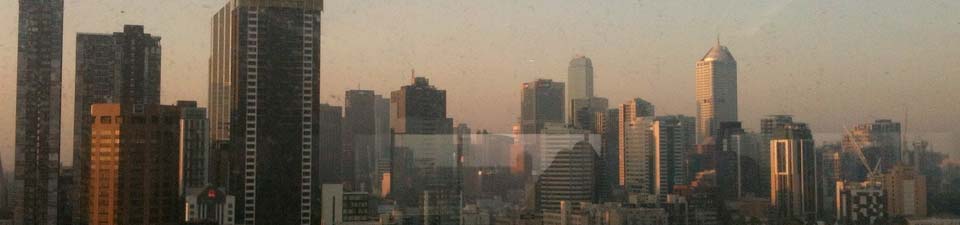 Die aufgehende Sonne spiegelt sich in der Skyline von Melbourne